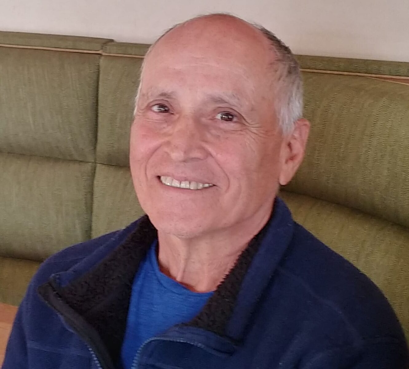 A man sitting on top of a green couch.