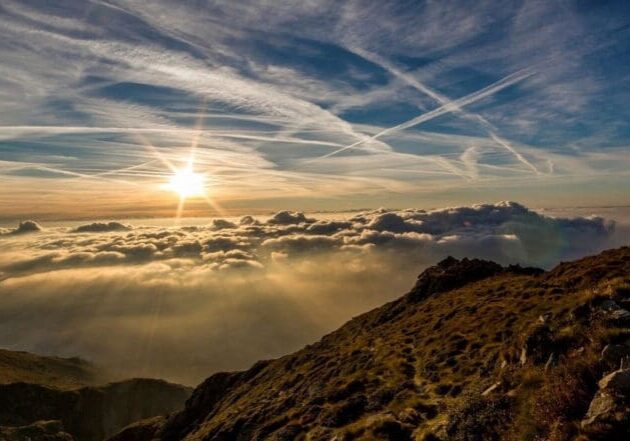 A view of the sun setting over some clouds.